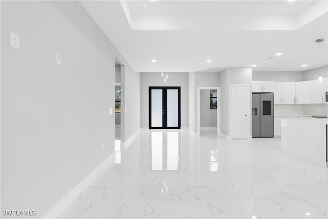 interior space with stainless steel fridge and white cabinetry