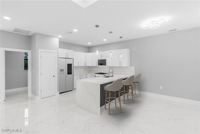 kitchen featuring kitchen peninsula, sink, white refrigerator with ice dispenser, decorative light fixtures, and white cabinetry