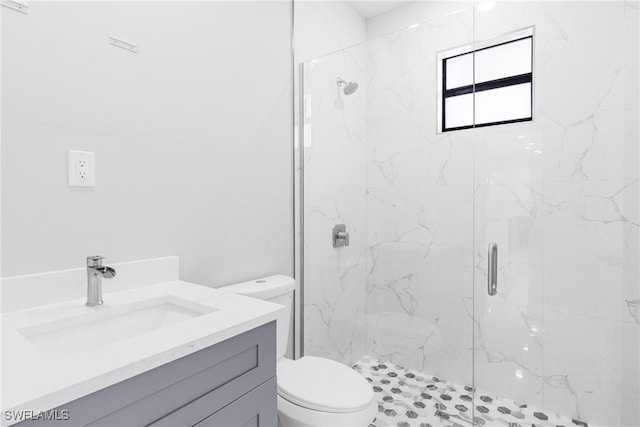 bathroom featuring vanity, an enclosed shower, and toilet