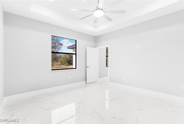 unfurnished room with a raised ceiling and ceiling fan