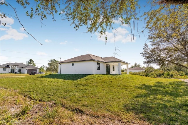 back of property featuring a yard