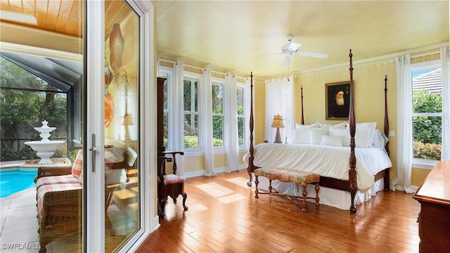 bedroom with multiple windows, ceiling fan, and light hardwood / wood-style floors