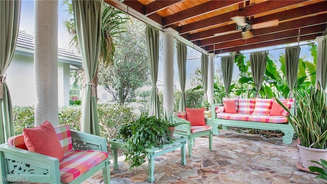 sunroom / solarium with beamed ceiling, ceiling fan, and wooden ceiling