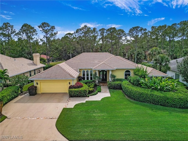 ranch-style home featuring a garage and a front lawn