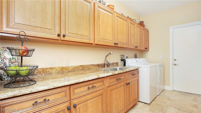 laundry area with separate washer and dryer, sink, and cabinets