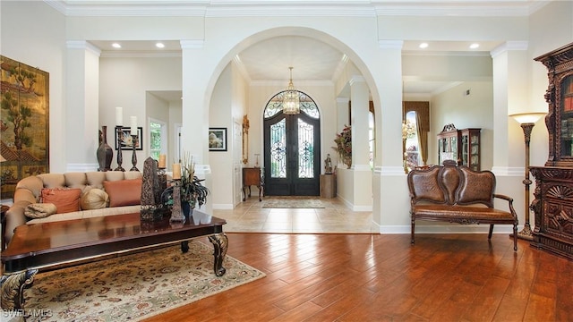 foyer entrance featuring french doors, light hardwood / wood-style flooring, and ornamental molding