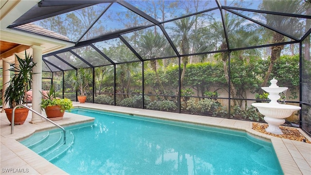 view of swimming pool featuring glass enclosure and a patio