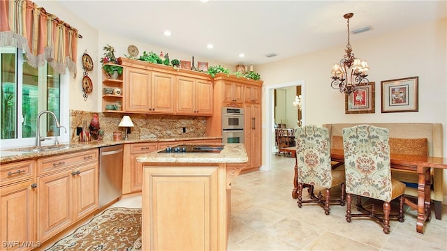 kitchen with stainless steel appliances, light brown cabinets, a chandelier, a center island, and a breakfast bar area