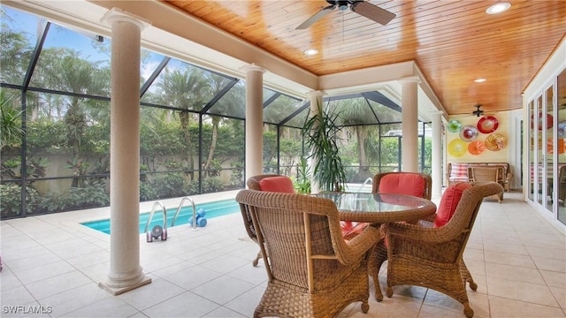 sunroom with ceiling fan, plenty of natural light, wood ceiling, and a pool