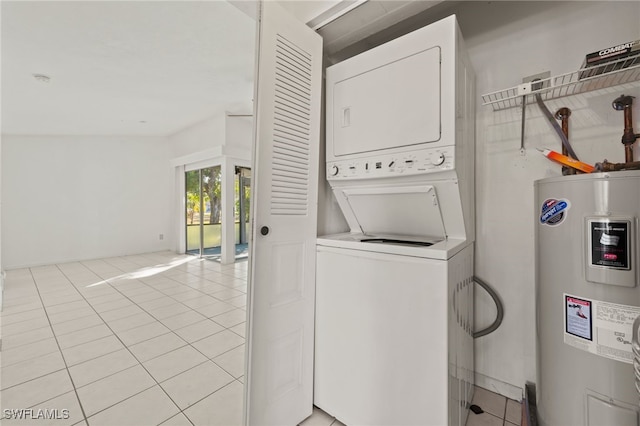 laundry area featuring water heater, stacked washer and dryer, and light tile patterned flooring