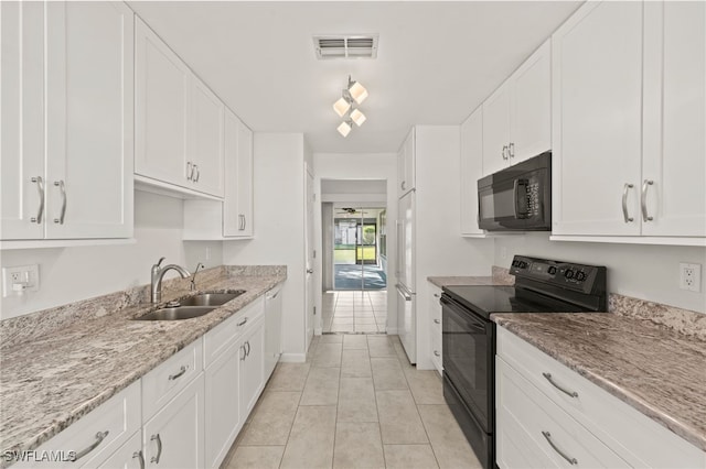 kitchen featuring black appliances, light stone counters, white cabinets, and sink