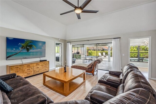 living room featuring hardwood / wood-style floors, ceiling fan, and a high ceiling