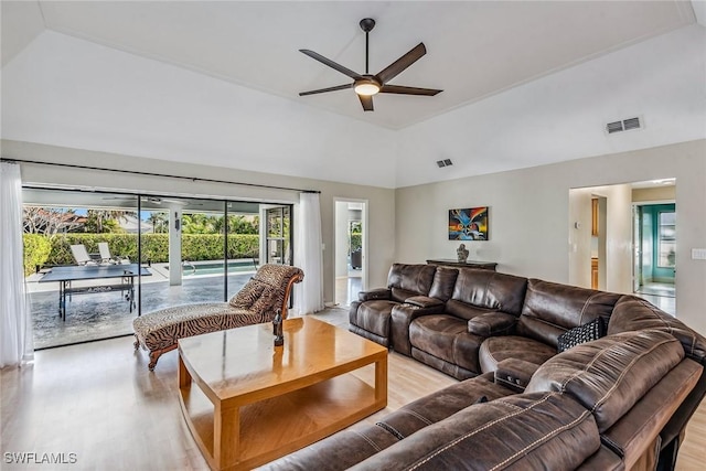 living room with light hardwood / wood-style floors, high vaulted ceiling, and ceiling fan