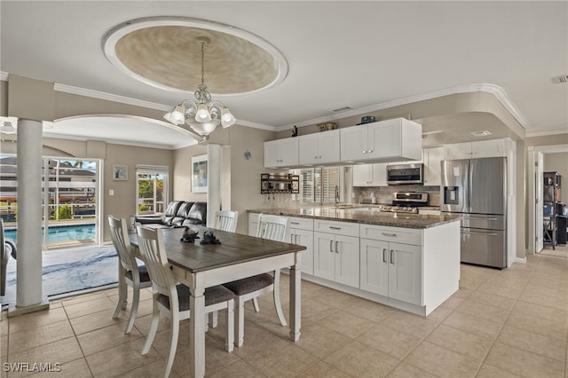 dining room with sink, a notable chandelier, crown molding, a tray ceiling, and light tile patterned flooring