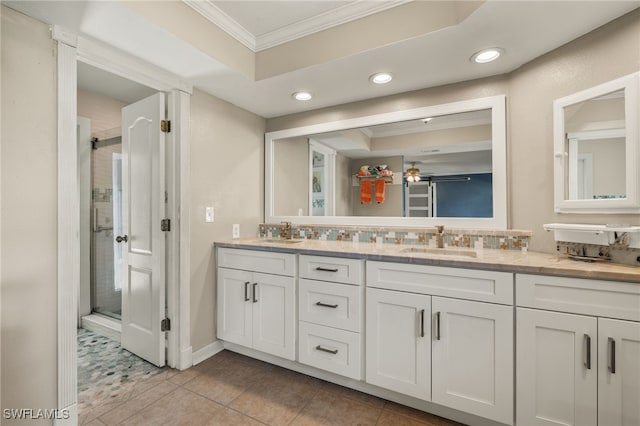 bathroom with tile patterned floors, vanity, a shower with door, ceiling fan, and crown molding