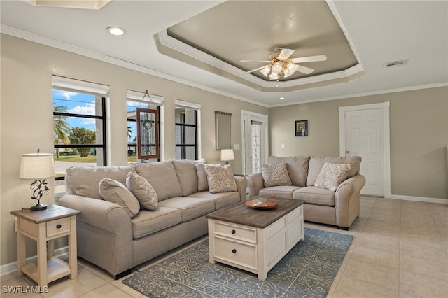 living room with ceiling fan, light tile patterned floors, crown molding, and a tray ceiling