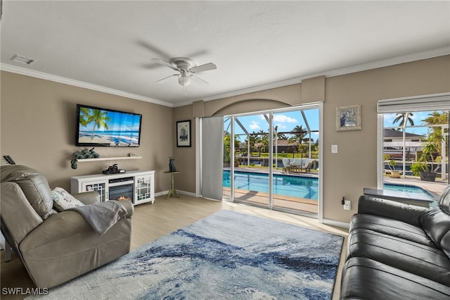 living room featuring ceiling fan, light hardwood / wood-style floors, and ornamental molding