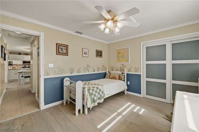 bedroom featuring ceiling fan, crown molding, and light hardwood / wood-style flooring