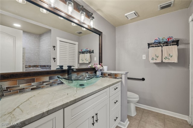 bathroom with tile patterned floors, vanity, toilet, and tasteful backsplash