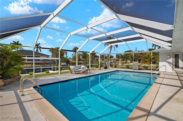 view of swimming pool with glass enclosure and a patio area