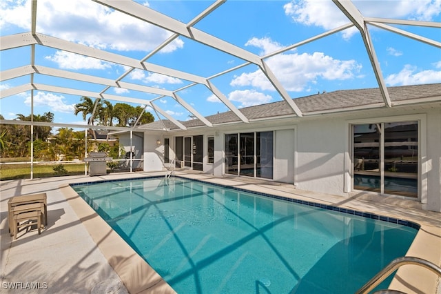 view of pool featuring glass enclosure and a patio area