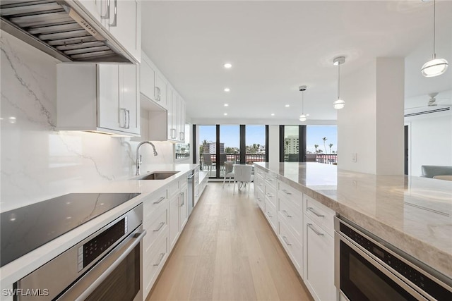 kitchen with pendant lighting, white cabinets, and appliances with stainless steel finishes