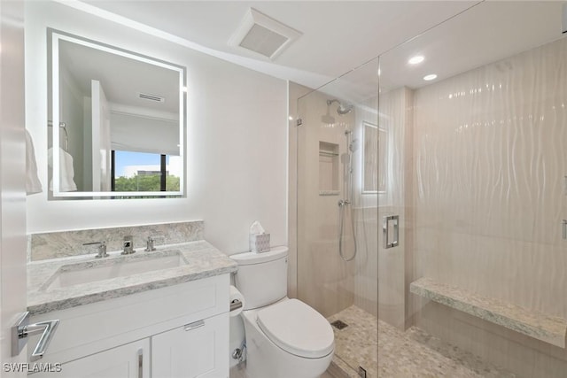 bathroom with vanity, toilet, and a shower with shower door