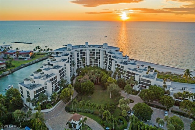 aerial view at dusk featuring a water view