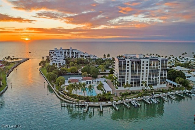 aerial view at dusk featuring a water view