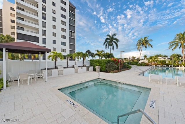 view of swimming pool featuring a gazebo, a grill, exterior kitchen, and a patio