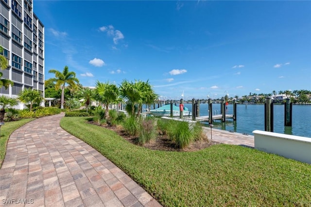 view of dock with a water view and a yard