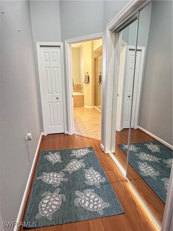 corridor with hardwood / wood-style flooring