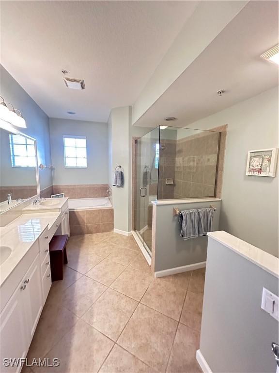 bathroom featuring tile patterned floors, vanity, and separate shower and tub