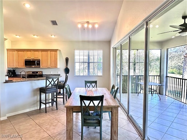 tiled dining area featuring ceiling fan and sink