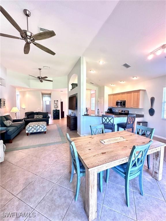 dining space with a wealth of natural light, ceiling fan, and light tile patterned floors