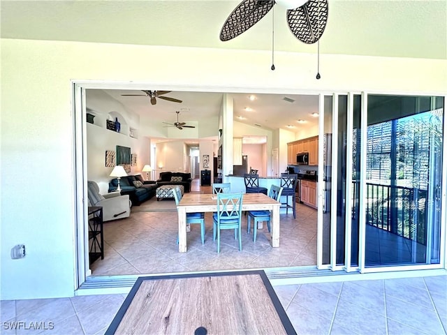 dining room with light tile patterned floors, ceiling fan, and lofted ceiling