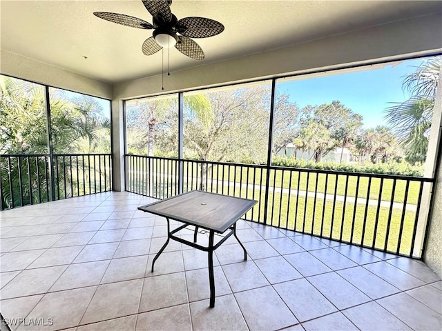 unfurnished sunroom with ceiling fan