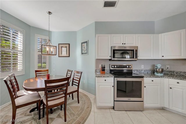 kitchen featuring light stone counters, visible vents, hanging light fixtures, appliances with stainless steel finishes, and white cabinets