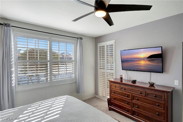 bedroom with baseboards, a ceiling fan, and light colored carpet