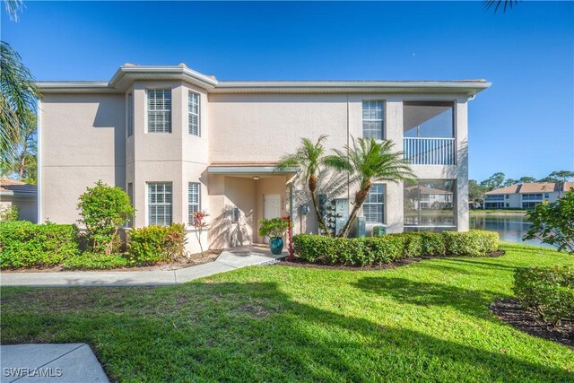 view of front of property featuring a front lawn and a water view