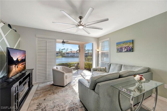 living area with a ceiling fan and a water view