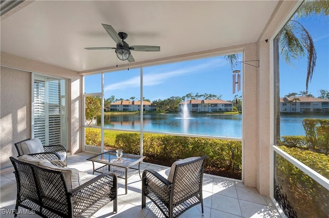 sunroom / solarium featuring a ceiling fan and a water view