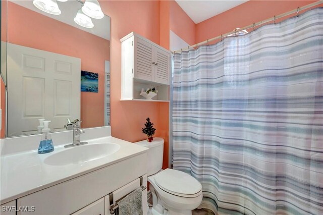 bathroom with a shower with shower curtain, vanity, and toilet