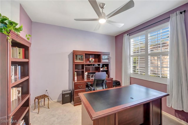 office space with baseboards, a ceiling fan, and light colored carpet