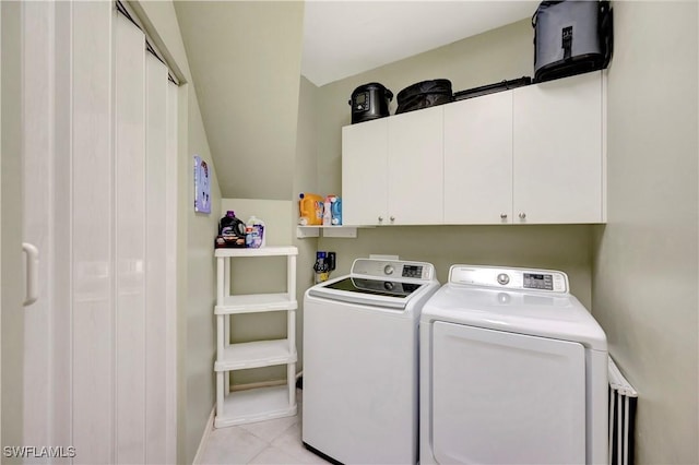 laundry area with baseboards, cabinet space, washing machine and clothes dryer, and light tile patterned floors