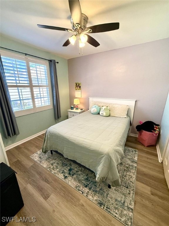 bedroom with ceiling fan, baseboards, and wood finished floors