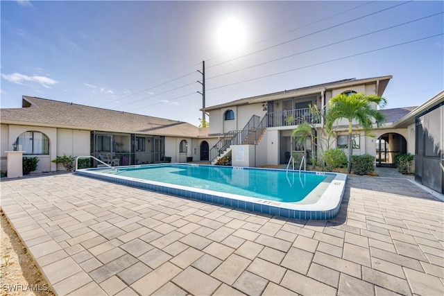 community pool featuring stairway and a patio area