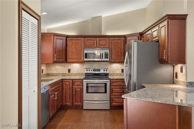 kitchen featuring decorative backsplash, dark hardwood / wood-style flooring, appliances with stainless steel finishes, and vaulted ceiling