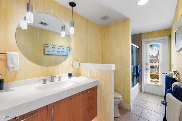 full bathroom with tile patterned flooring, vanity, toilet, and bath / shower combo with glass door