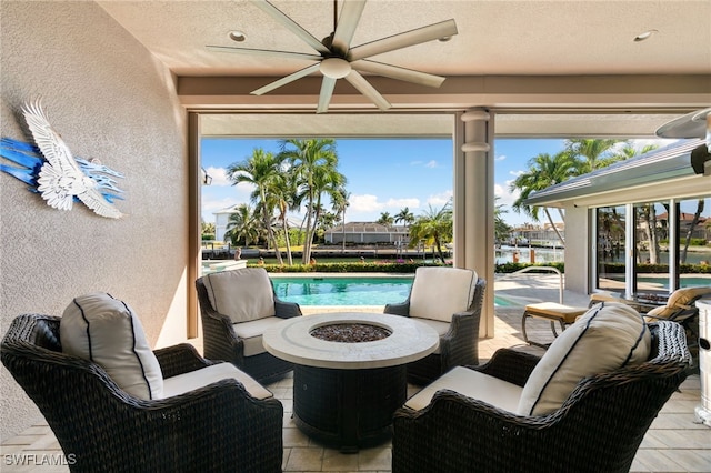 view of patio with ceiling fan and an outdoor living space with a fire pit